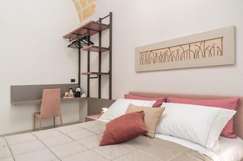 a bedroom with a white bed with red pillows at Michelangelo B&B in Lecce