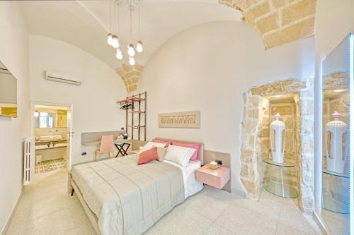 - une chambre avec un lit et un mur en pierre dans l'établissement Michelangelo B&B, à Lecce