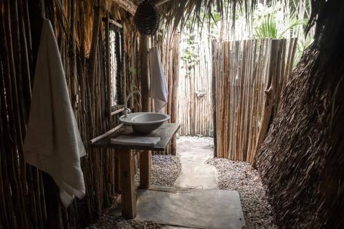 a bathroom with a sink on a wooden wall at La Colmena RD in Santa Bárbara de Samaná