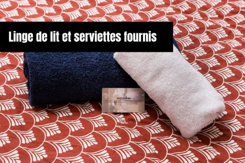 a pair of towels and a box on a bed at Chambre hote - Dormir comme à la maison - in Châteaubriant