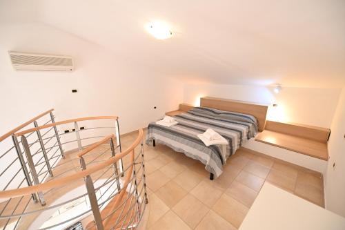 a small room with a bed and a staircase at Aba Village RTA in Puntone di Scarlino