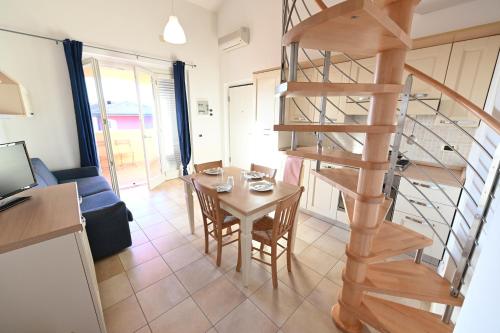 a living room with a spiral staircase and a table at Aba Village RTA in Puntone di Scarlino