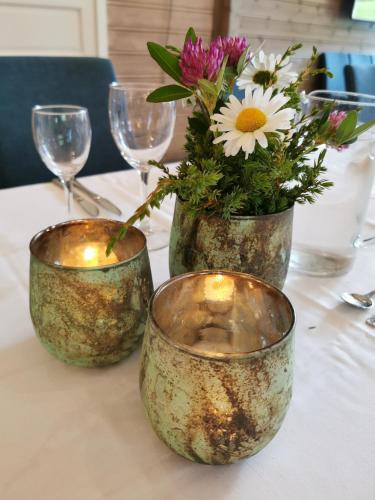 two vases with flowers in them on a table at Grønolen Fjellgard in Beitostøl