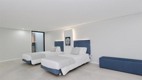 two beds in a room with white and blue at Villa Waterfall - Clever Details, luxury, 5min walking from the center in Vilamoura