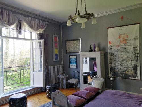 a bedroom with a bed and a large window at Manoir le Louis XXI in Masnières