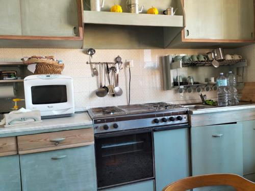 a kitchen with a stove and a microwave at Carru de ammentos in Ozieri