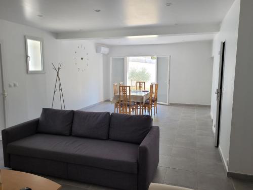 uma sala de estar com um sofá e uma mesa em Villa entière de 145m² calme en petite Camargue em Beauvoisin