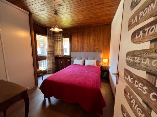 - une chambre avec un lit doté d'un couvre-lit rouge dans l'établissement ELAN 15 appartement 6 pers, centre village, à La Clusaz