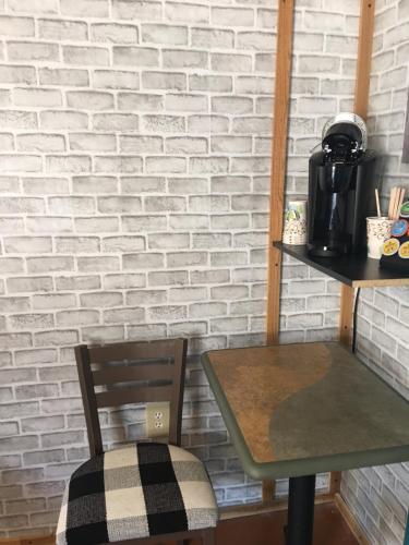 una mesa y una silla junto a una pared de ladrillo en Acorn Hideaways Canton Cozy Frontier Rm for 3 Full Bathtub, en Canton