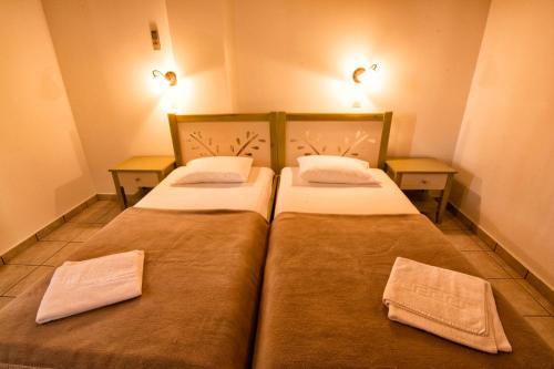 - deux lits jumeaux dans une petite chambre avec deux tables dans l'établissement Villas Paleochora, à Paleóchora