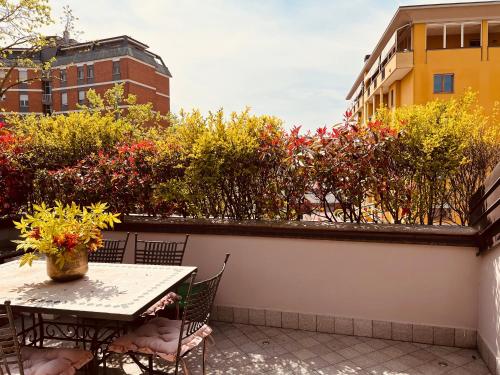 a table and chairs on a balcony with flowers at Appartamento incantevole a piacenza in Piacenza
