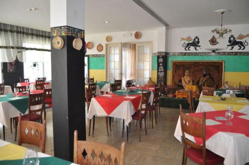 Hotel Rigobello في ريتشيوني: مطعم فيه طاولات وكراسي وناس في الخلف