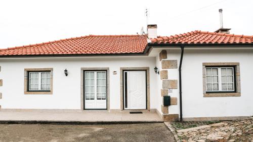 een wit huis met een rood dak bij Casa da BellaVista in Ponte de Lima