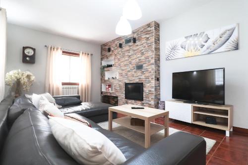 a living room with a couch and a tv at Casa da BellaVista in Ponte de Lima