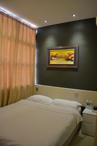 a bedroom with a bed and a painting on the wall at Putra One Avenue Hotel in Seri Kembangan