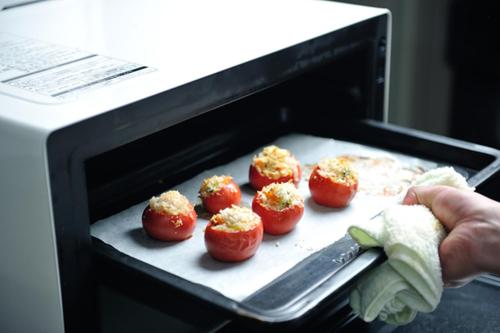 a person is putting food in a toaster oven at Hotel Takimoto in Yamanouchi