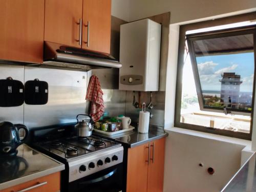 uma cozinha com um fogão e uma janela em Excelente departamento, a pasos del Shopping LA PAZ, vista al río Paraná, cochera techada privada - silencio - ideal para descansar - barrio residencial em Paraná