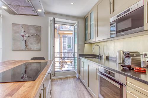 d'une cuisine équipée d'appareils en acier inoxydable et d'une grande fenêtre. dans l'établissement Style in Cannes-Beautiful Apt-5 mins stroll to Festival-Beach-Port, à Cannes