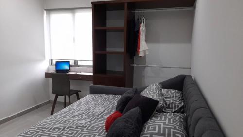 sala de estar con sofá y escritorio en Gorgeous Apartment HOEStel Long Island!, en Cancún