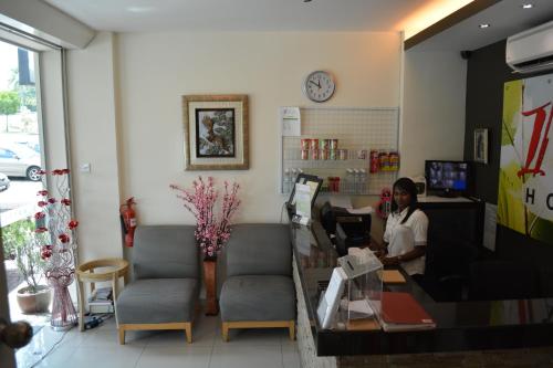 a woman standing at a counter in a store at Putra One Avenue Hotel in Seri Kembangan