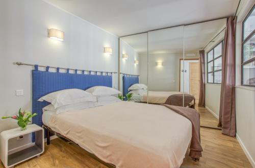 a bedroom with a large bed and a mirror at Style in Cannes-Beautiful Apt-5 mins stroll to Festival-Beach-Port in Cannes
