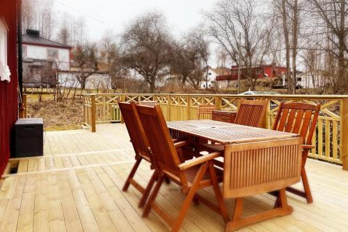 a wooden table and chairs on a deck at Photoeverhome in Bengtsfors