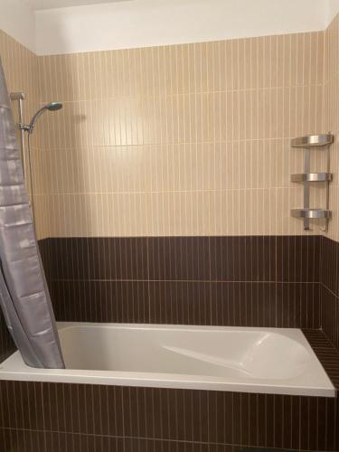 a bath tub in a bathroom with brown tile at Great Kings Resort, Kapparis, Cyprus - Self Catering Apartment, Sleeps 6 in Paralimni