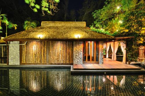ein kleines Haus an einem Pool bei Nacht in der Unterkunft The Journey Resort Pattaya in Na Jomtien