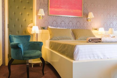 a bedroom with a bed and a blue chair at Villa Katarina in Budva