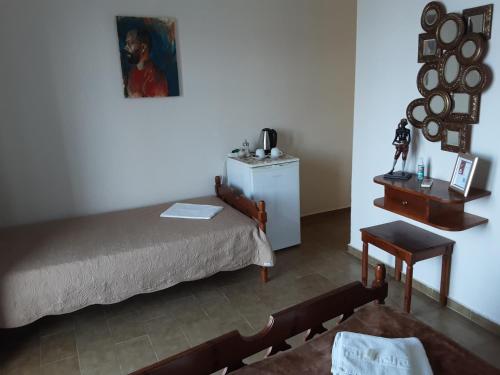 1 dormitorio con 1 cama, 1 mesa y 1 silla en Remezzo, en Mókhlos
