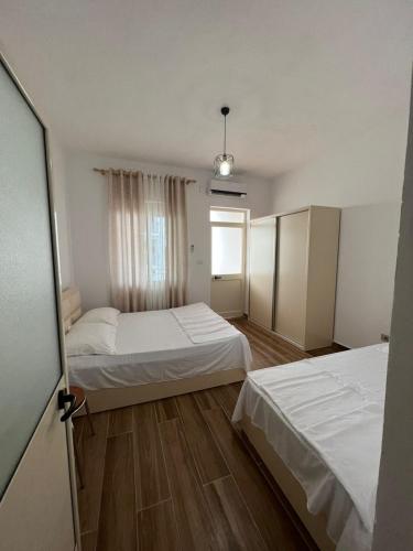 a bedroom with two beds and a window at Perdja Apartment II in Velipojë