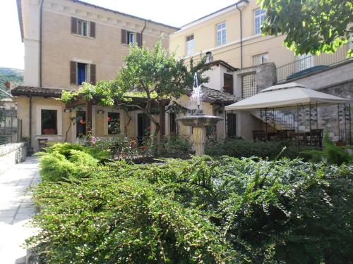 a garden in front of a building with a fountain at Antica Dimora Fuori Le Mura B&B in Scanno