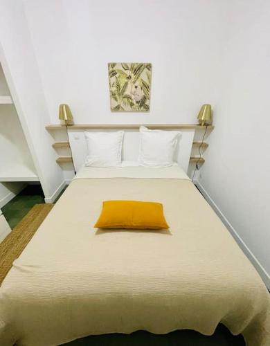 a bedroom with a large bed with a yellow pillow at LA MOUNINE - Hyper centre - 37m2 - 4 pers in Cassis