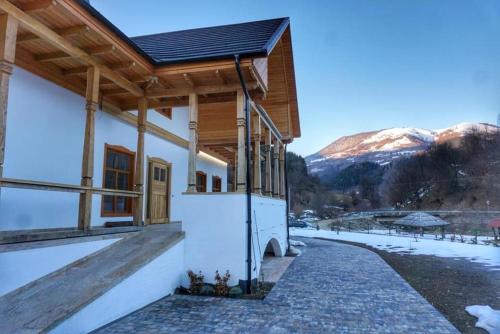 a house with snowy mountains in the background at Conacul Sanct Gurgh in Cormaia