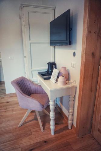 a desk with a chair and a television on it at Conacul Sanct Gurgh in Cormaia