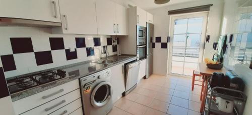 a kitchen with a washer and dryer in it at Ria Formosa Beach Apartment in Cabanas de Tavira