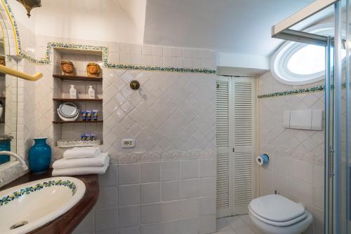 a bathroom with a toilet and a sink and a shower at CasaMia Positano - sea view and private outdoor hot tub in Positano