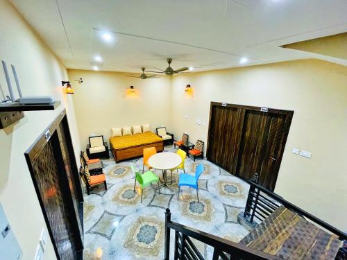 uma sala de estar com um sofá, uma mesa e cadeiras em The Orchid Retreat em Agra