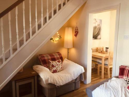 a living room with a chair and a staircase at Boutique Cottage In The Heart Of Buxton Town in Buxton