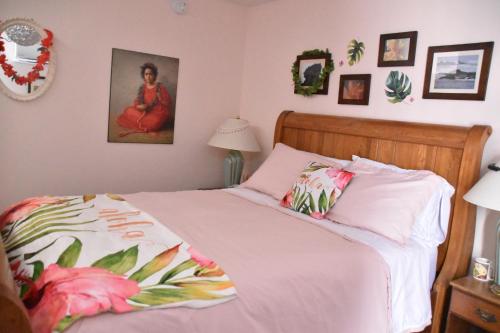 een slaapkamer met een bed met een roze dekbed bij Seabank House Bed and Breakfast Aloha in Pictou