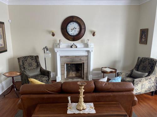 a living room with a couch and a clock on the wall at Seabank House Bed and Breakfast Aloha in Pictou