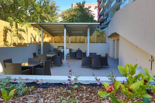a patio area with chairs, tables, and umbrellas at Gladstone Central Plaza in Gladstone