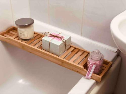 a shelf in a bath tub with a box and a candle at Boutique Cottage In The Heart Of Buxton Town in Buxton