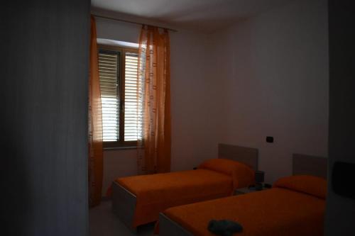 a small room with two beds and a window at A casa di Gió e Chri in Minturno