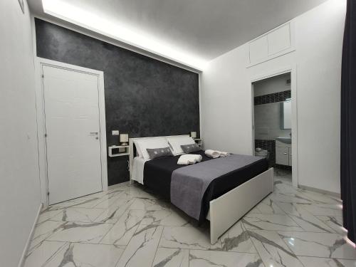 a bedroom with a bed and a black and white wall at GioRi in Giardini Naxos