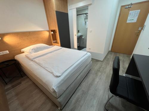 a bedroom with a bed and a desk and a television at Garni Hotel Cirman in Ljubljana