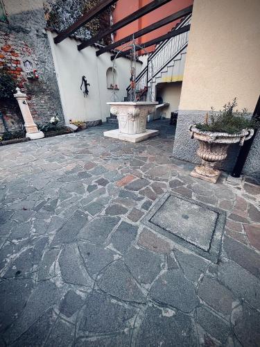 a stone patio with a fountain in a building at B&B Corte sul Naviglio CIN I T 0 1 5 0 7 0 C 1 3 X U I L Q C V in Cernusco sul Naviglio
