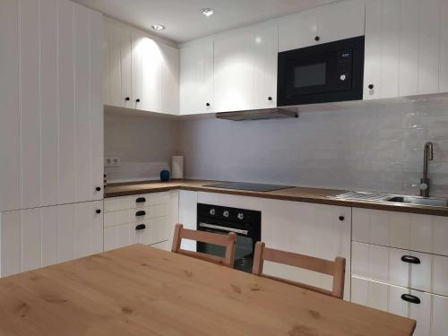 a kitchen with a wooden table and a microwave at Casa Calpurnia Cerler in Cerler