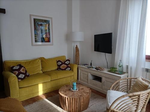 - un salon avec un canapé jaune et une télévision dans l'établissement Casale Il Girasole, à San Costanzo