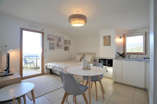 un salon avec un lit, une table et des chaises dans l'établissement STUDIO dernier étage avec terrasse - vue montagne, à Cruseilles